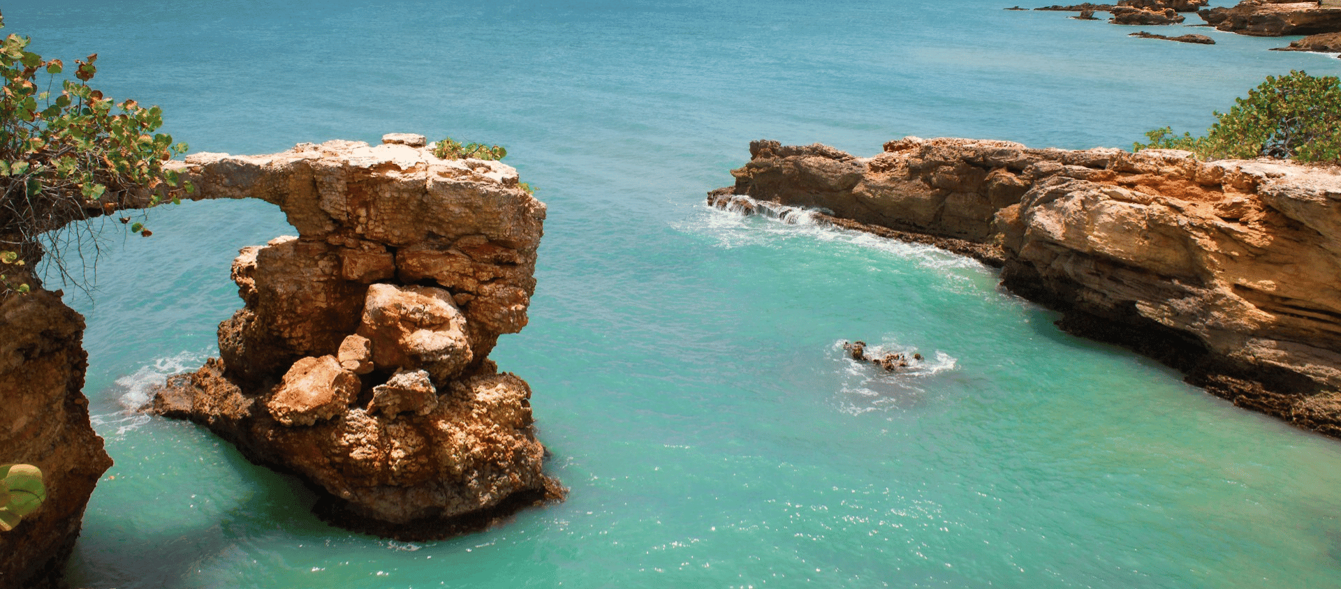 Turquoise waters and a natural rock arch along the coast of Puerto Rico.