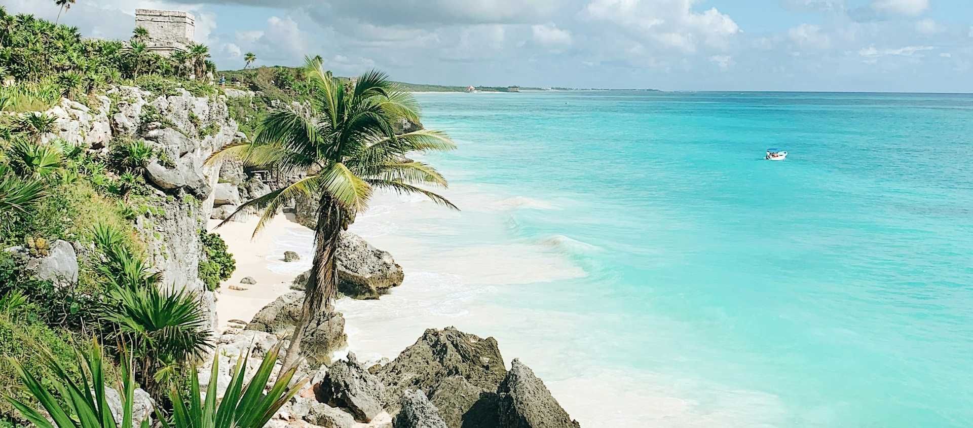 Mayan ruin on a cliff above the turquoise water and white-sand beach at Tulum on Mexico's Caribbean coast.