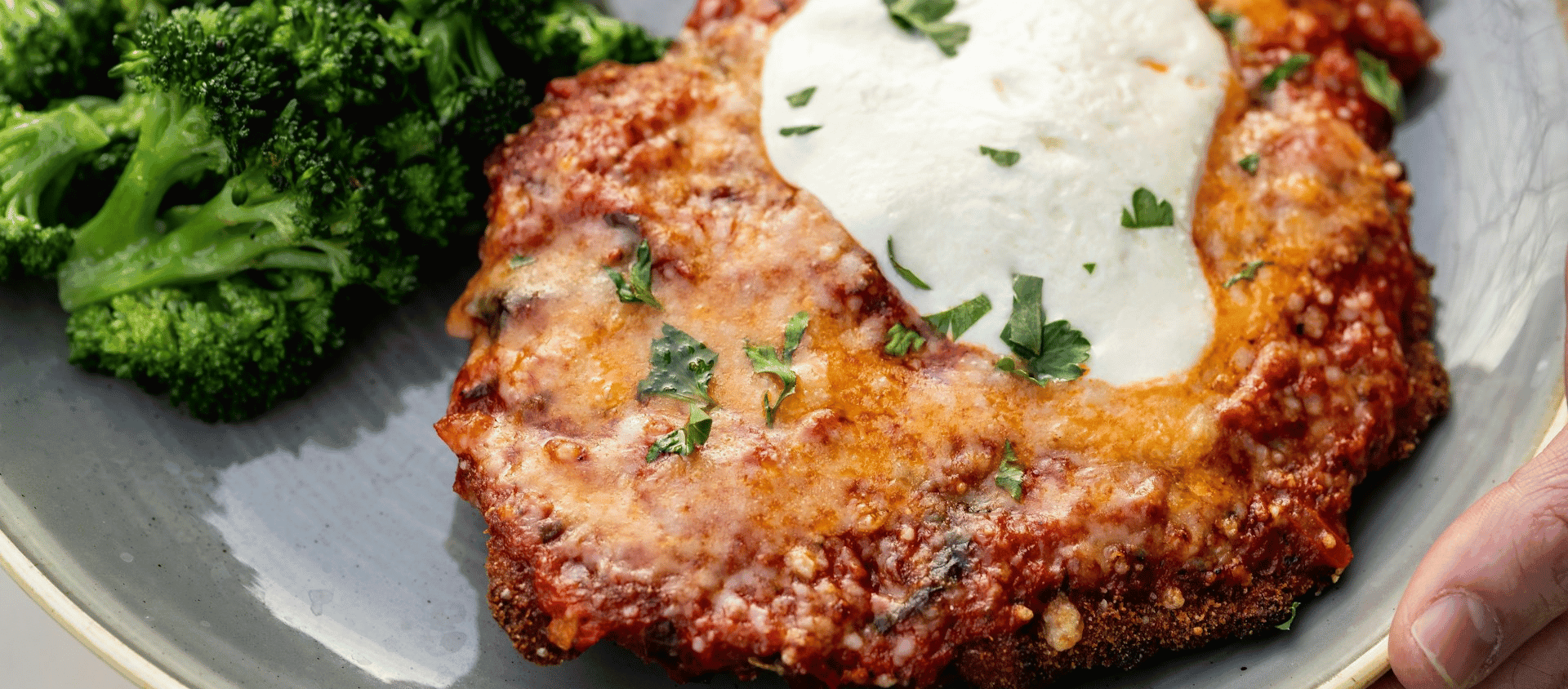 Chicken Parmesan topped with melted cheese and sauce.
