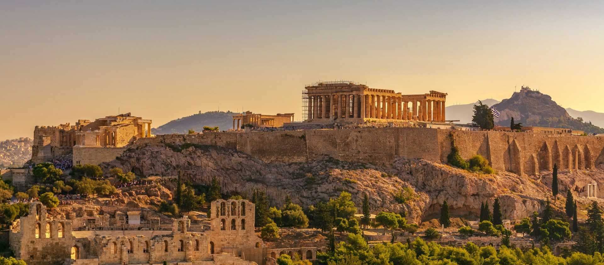 The Parthenon atop the Acropolis overlooking Athens at sunset in Greece.