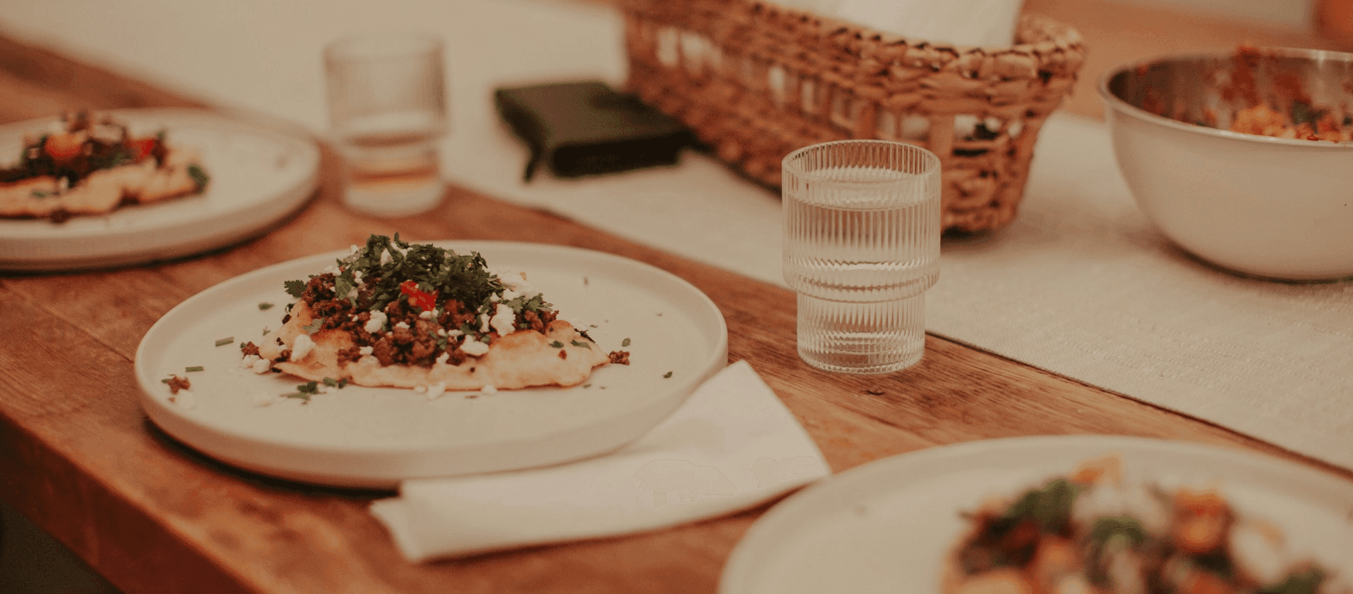 A wooden table topped with plates of food