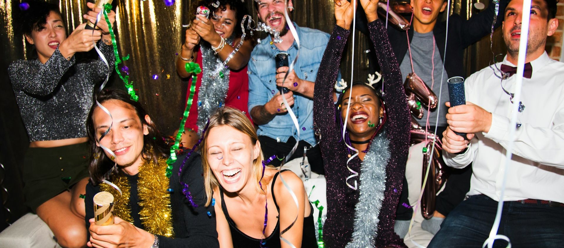 Friends celebrating a 30th birthday party weekend trip with streamers and drinks.