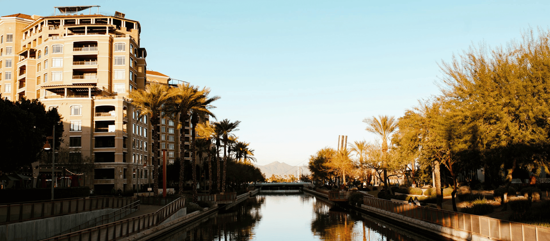 Old Town Scottsdale canal with palm trees and buildings.