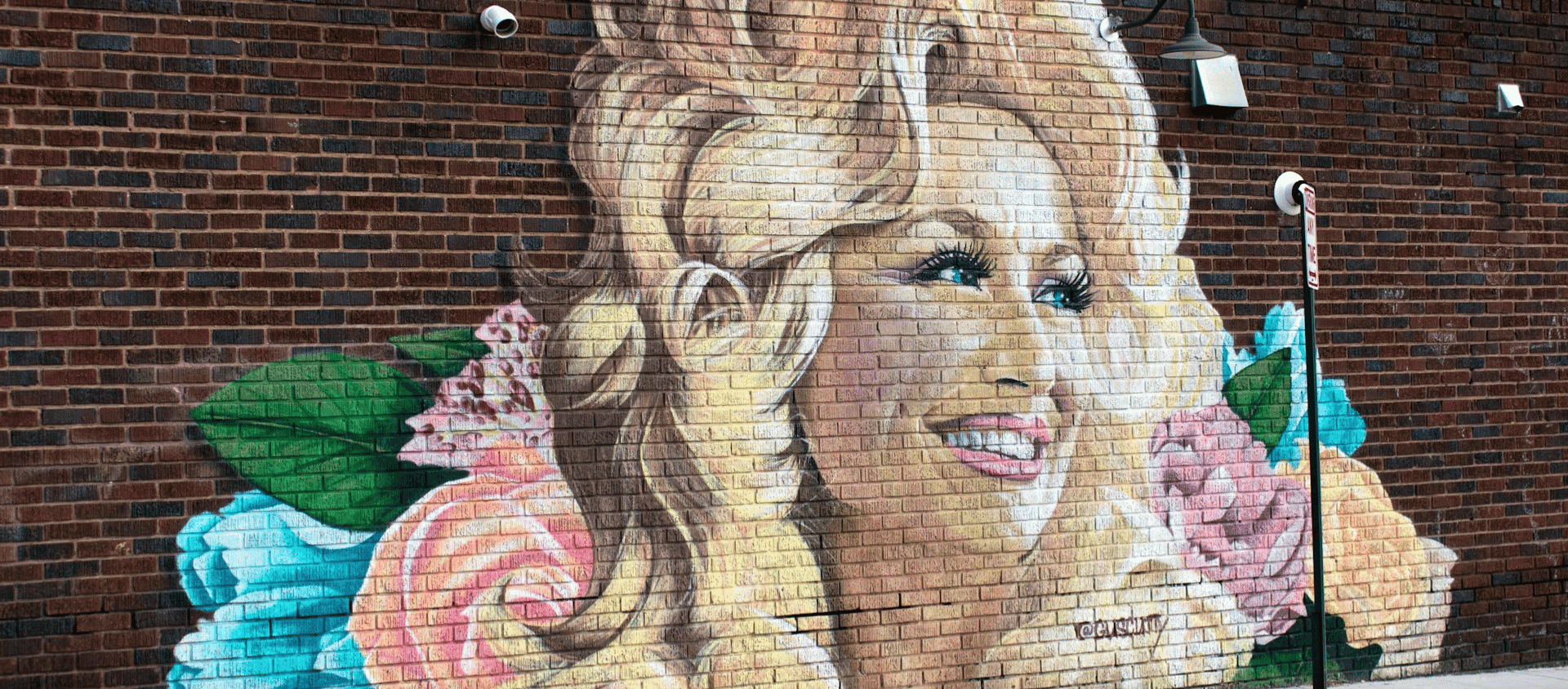 Large Dolly Parton mural painted on a brick building in Asheville's River Arts District.