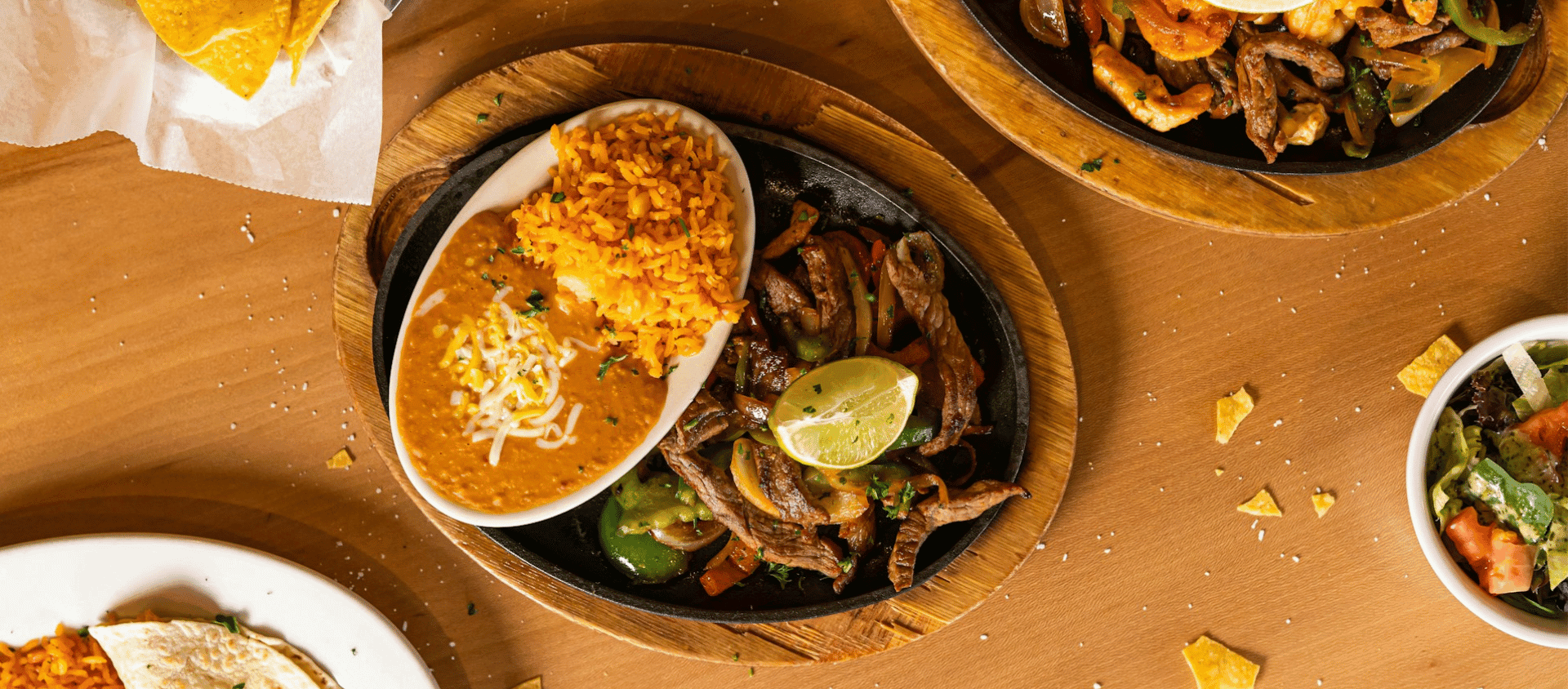 Steak fajitas served with tortillas and toppings.