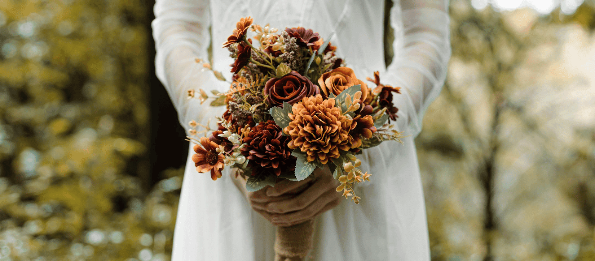 Bride holding a bouquet of autumn-colored flowers.