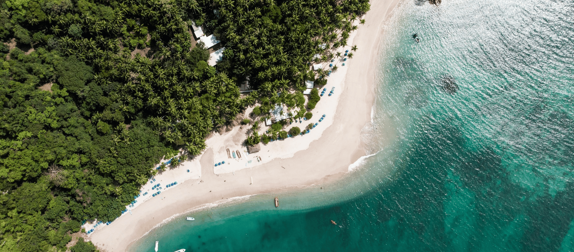 Aerial view of white sand beach and emerald water in Costa Rica.