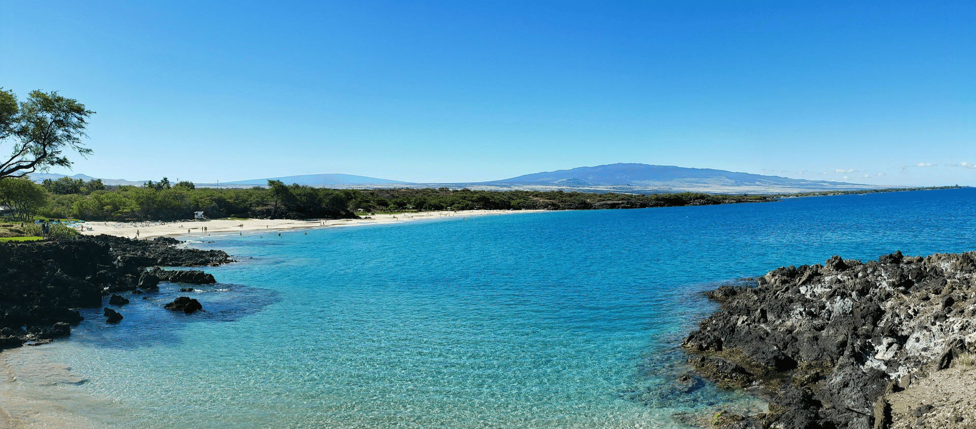 Scenic Hawaii coastline with volcanic rocks and blue sea.