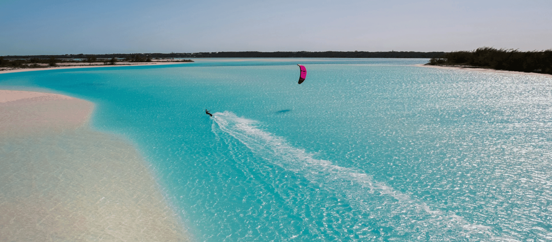Kiteboarder over shallow turquoise sandbars in the Bahamas
