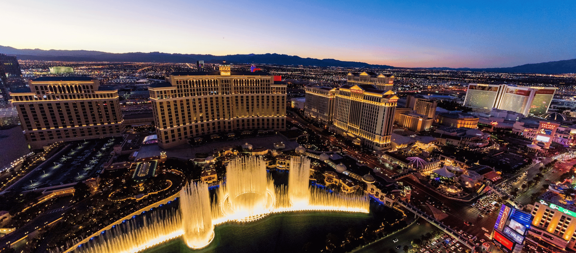 Fountains of Bellagio lit up on Las Vegas strip at dusk