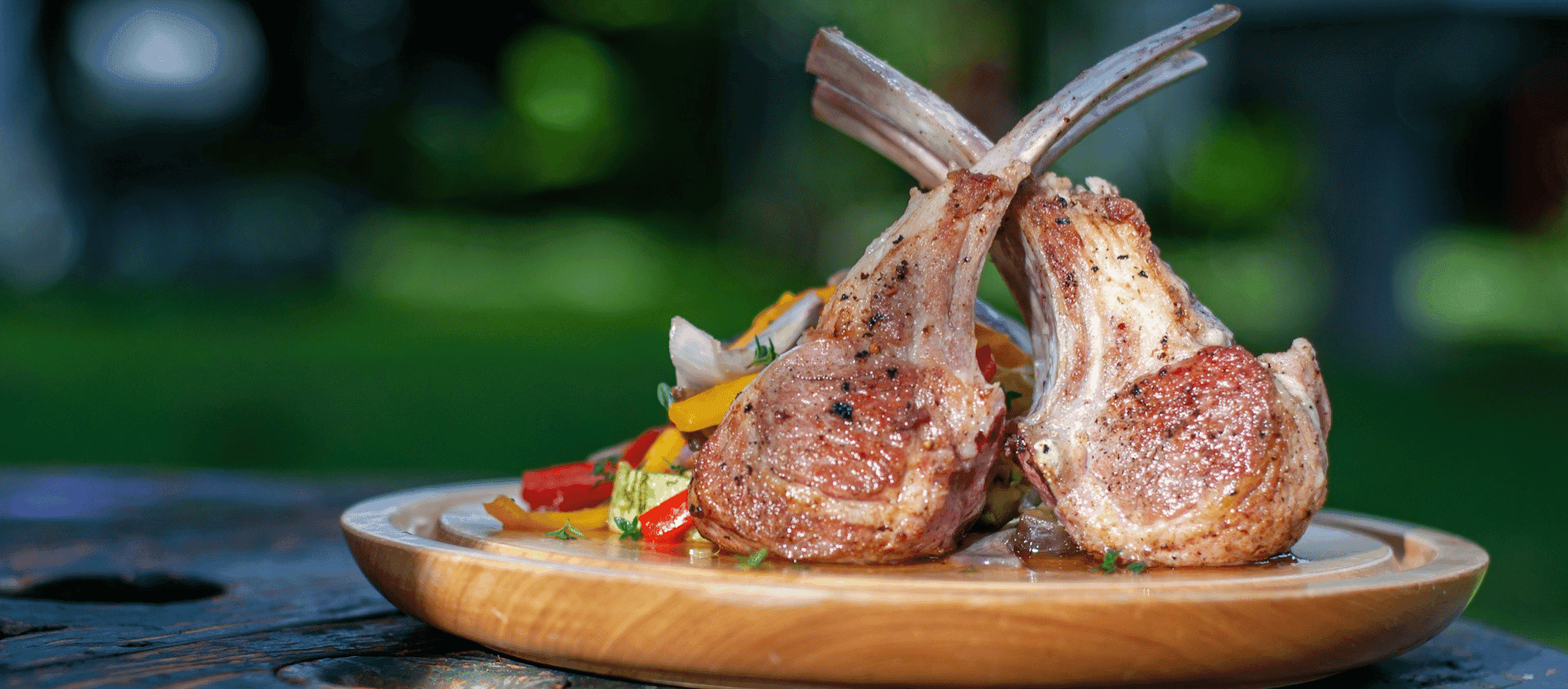 Rack of lamb plated with vegetables.