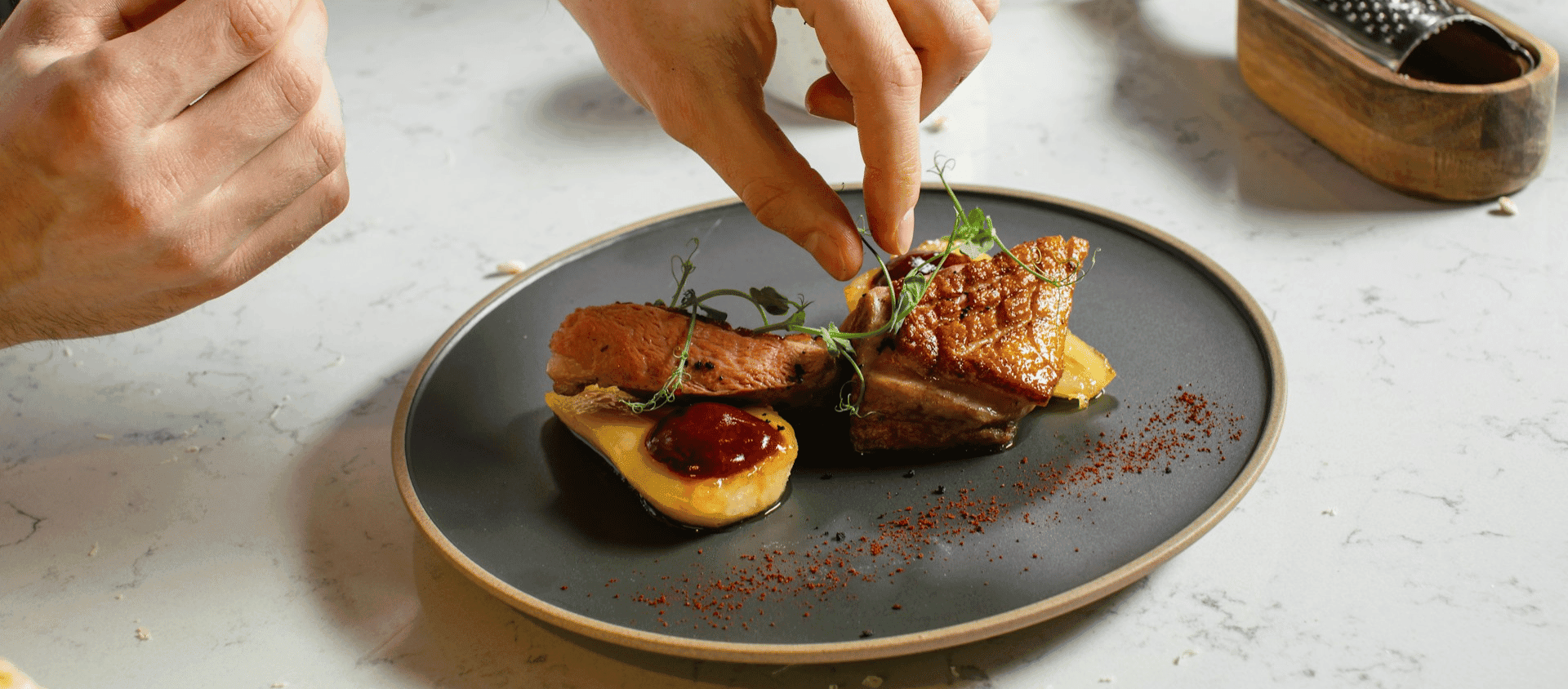 Duck breast plated with sauce and garnish.