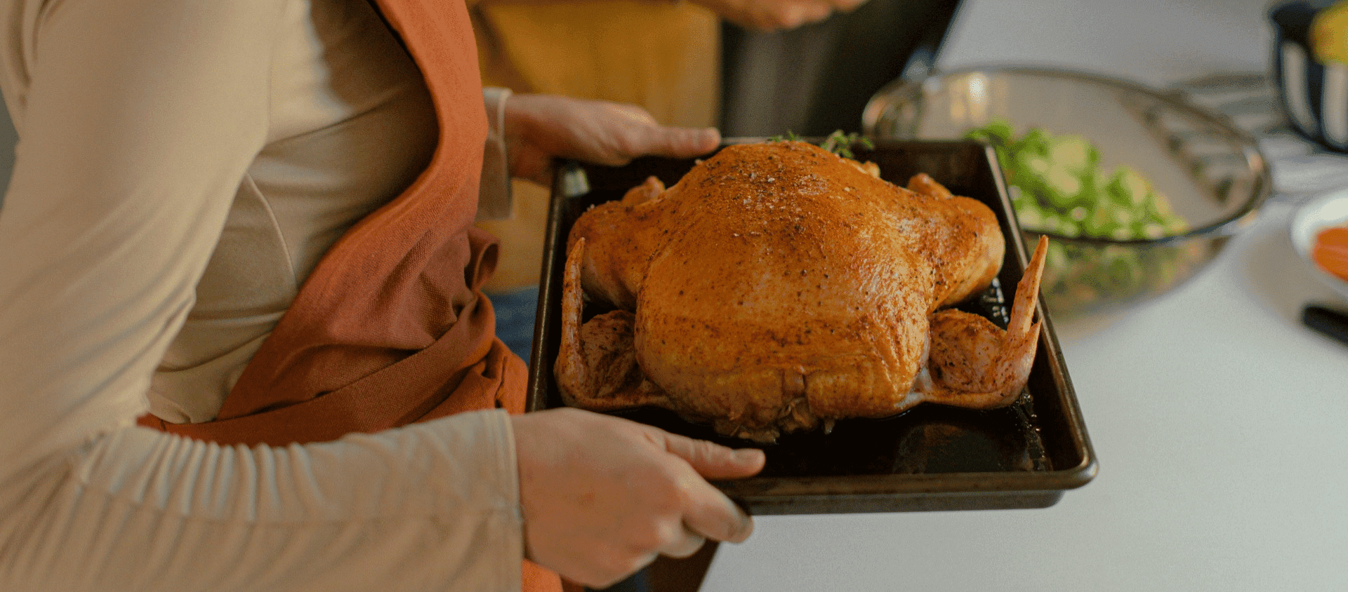Whole roasted chicken on a tray with crispy skin.
