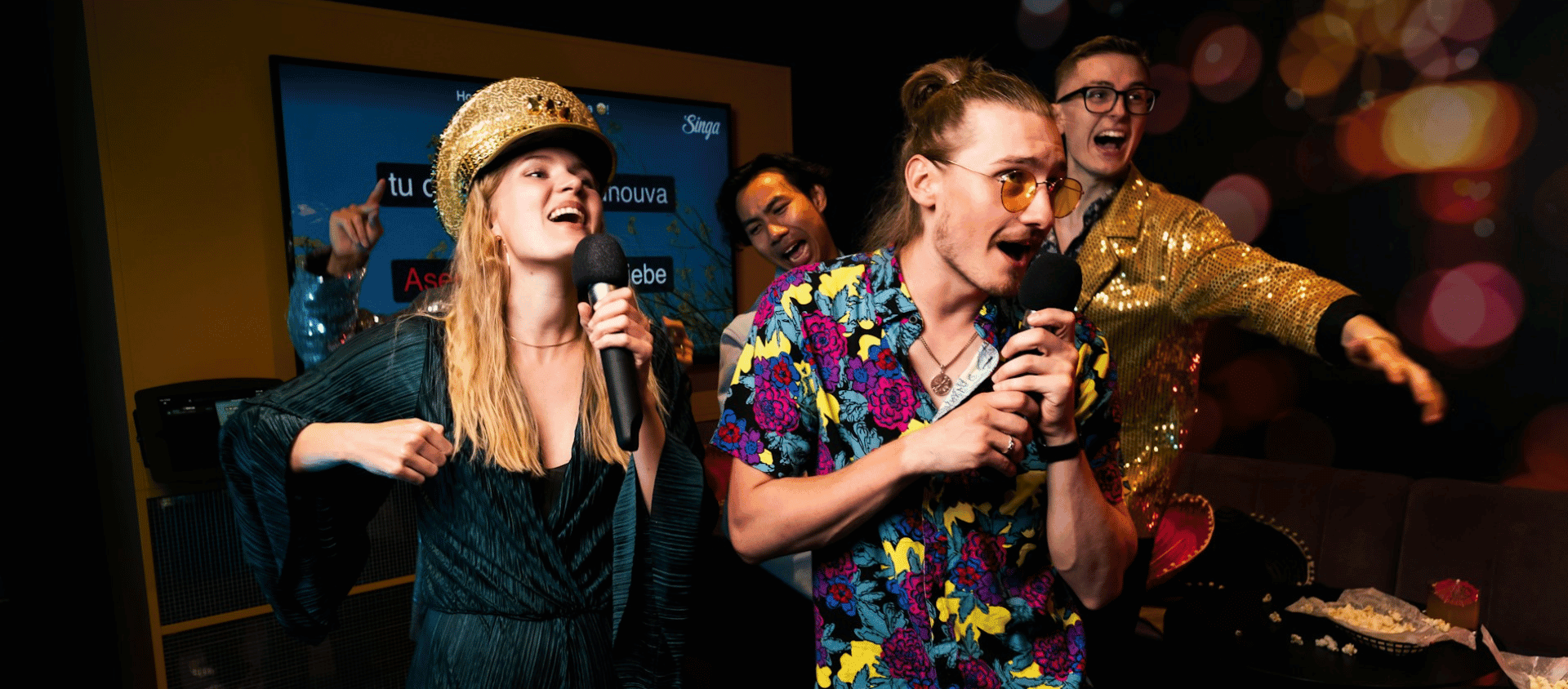 A group of people performing karaoke in a room.