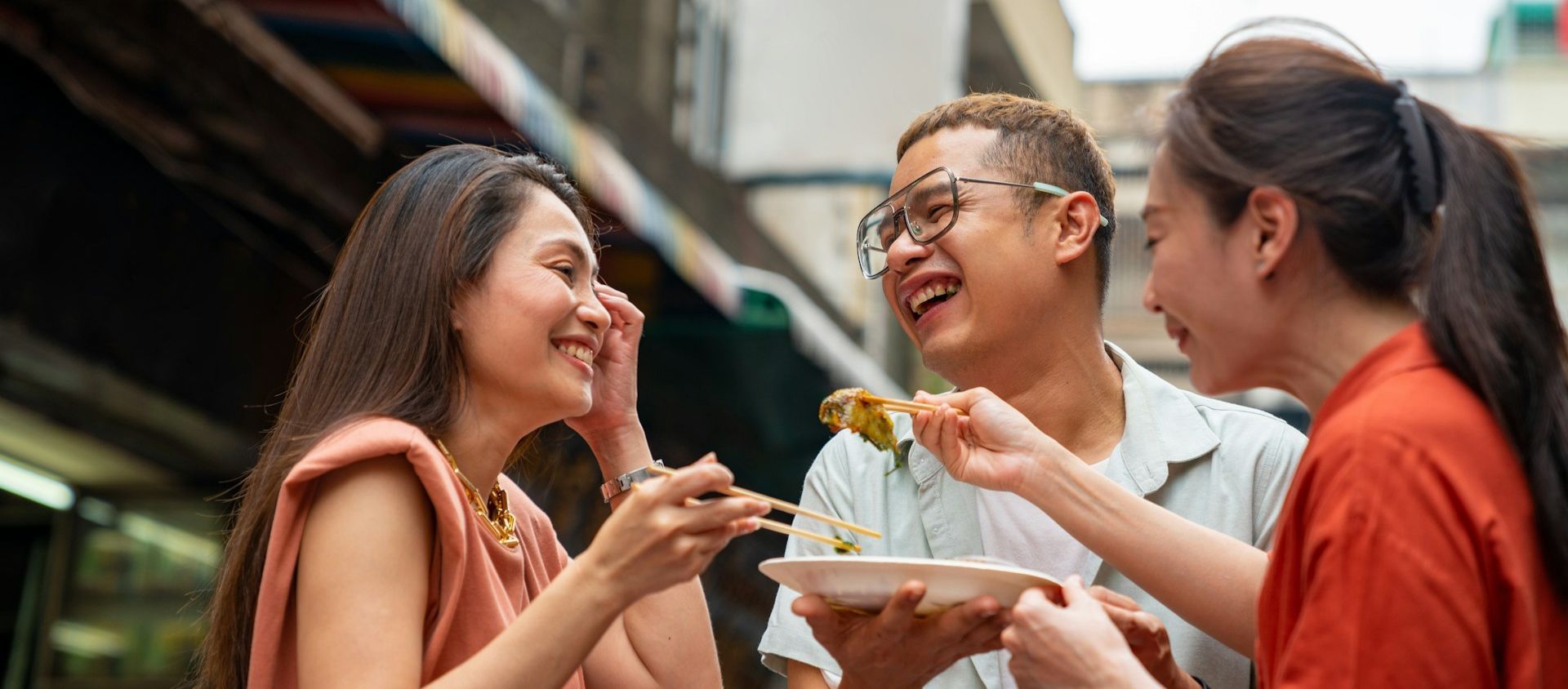 Friends celebrating a 30th birthday foodie trip at an outdoor restaurant.
