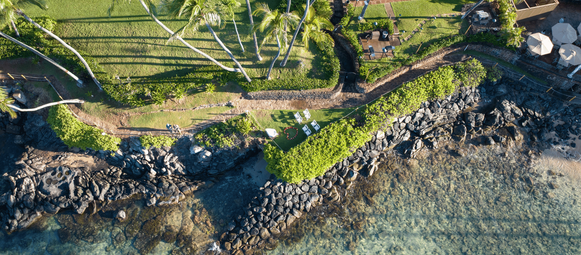 Aerial view of Maui coastline at Napili Kai Beach Resort with lush greenery and ocean.