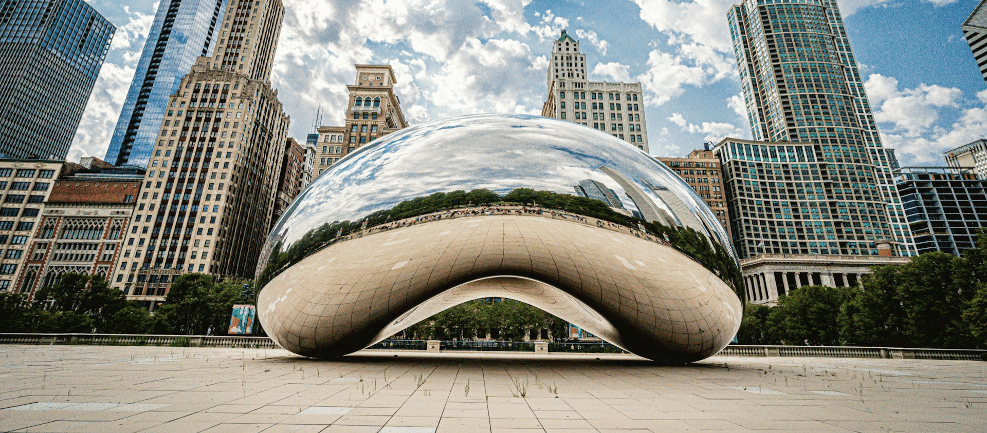 Cloud Gate sculpture in Chicago with city skyline reflected on its surface.