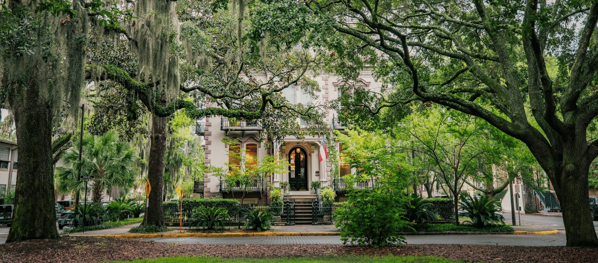 Oak-lined historic square with Spanish moss and antebellum buildings in Savannah, Georgia.