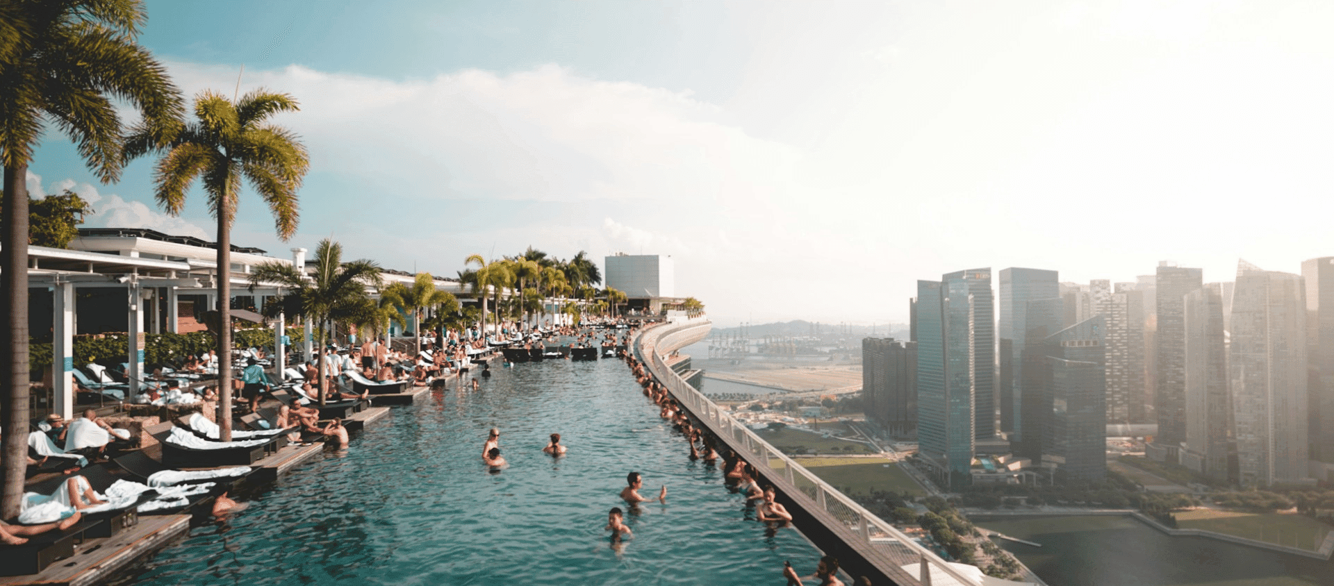 Guests relaxing in the rooftop infinity pool at Marina Bay Sands overlooking the Singapore skyline