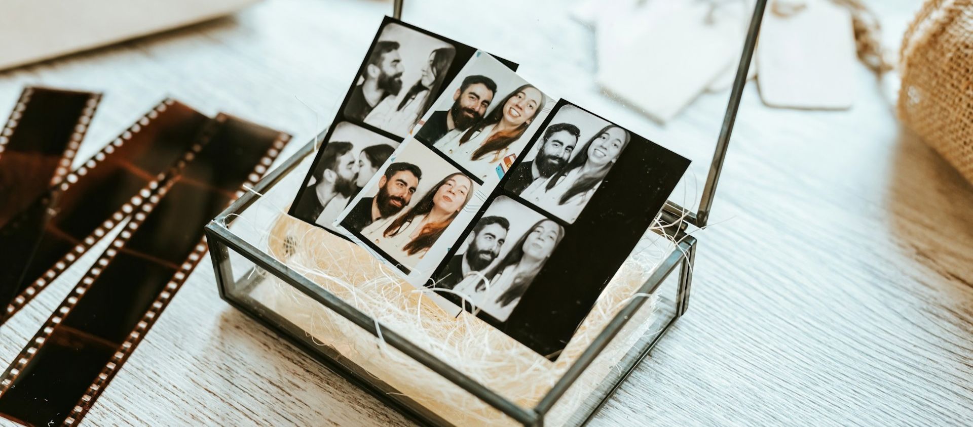 Photo booth prints of two people displayed in a glass keepsake box.