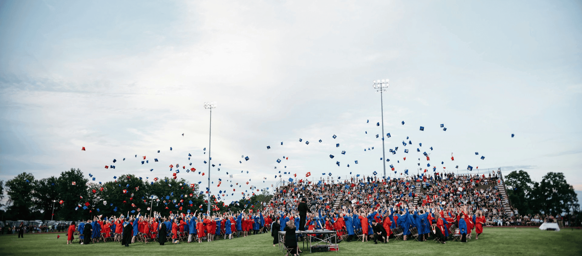 A group of high school students throwing their caps at graduation.