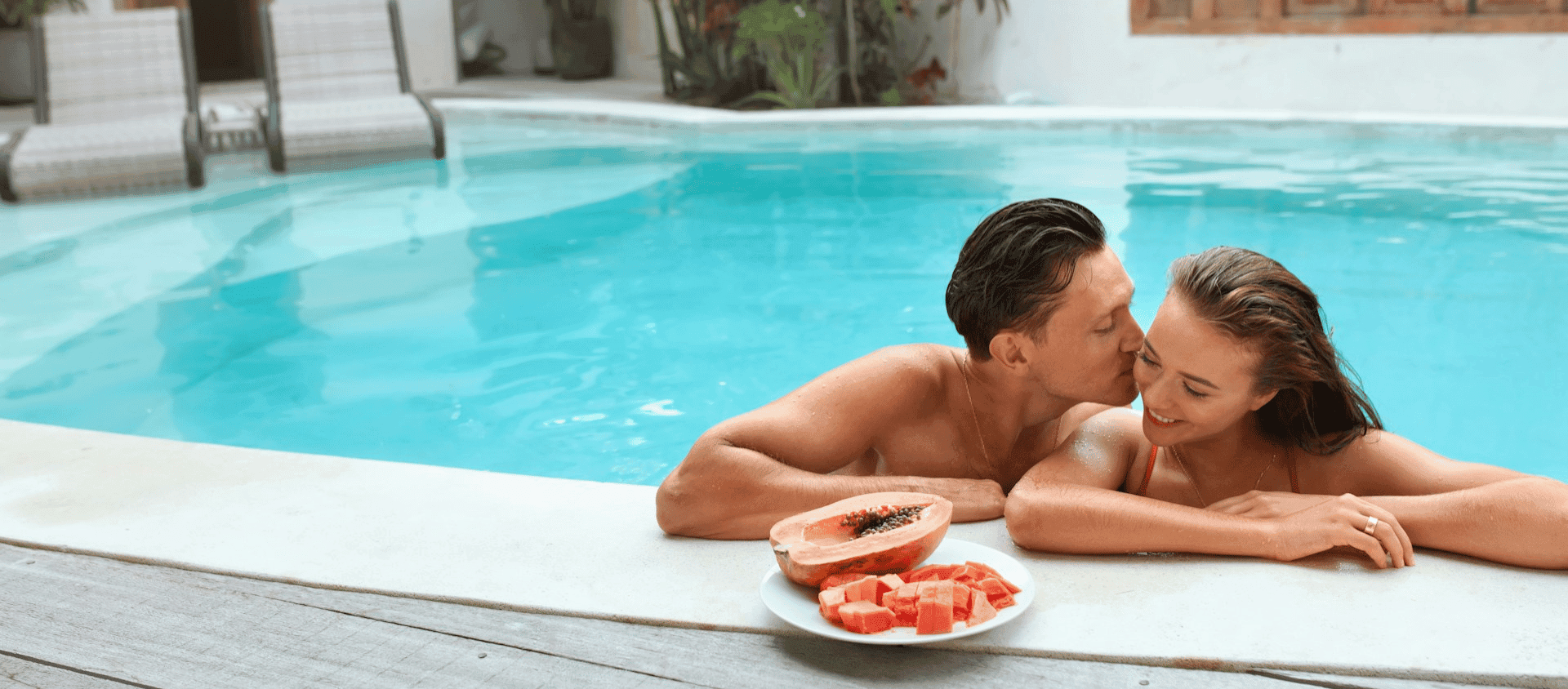 Couple sharing a plate of fruit while in the pool
