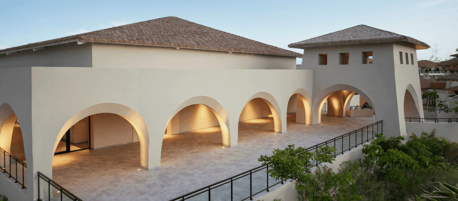 Oceanview terrace event space with arched architecture at dusk at Dreams Playa Esmeralda.