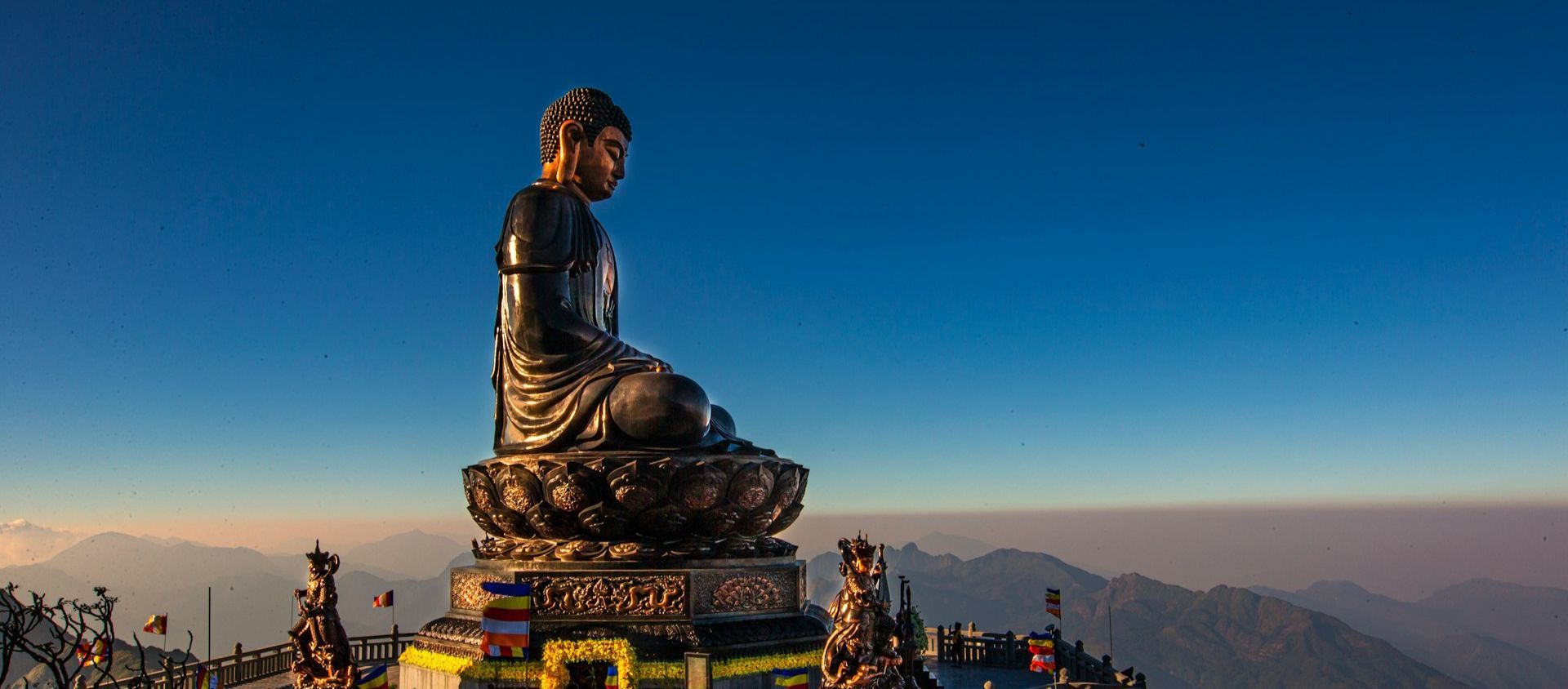 Buddha statue with mountains in the background.