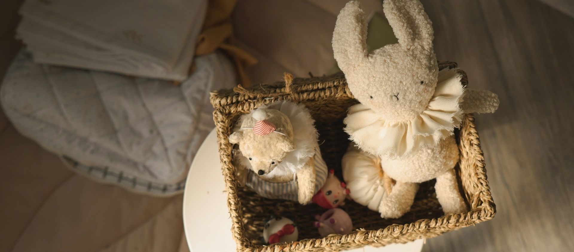 A woven basket of soft plush toys in a nursery.
