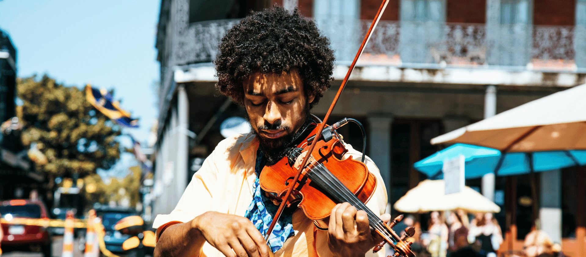 Street musician playing violin on a sunny afternoon in the New Orleans French Quarter.