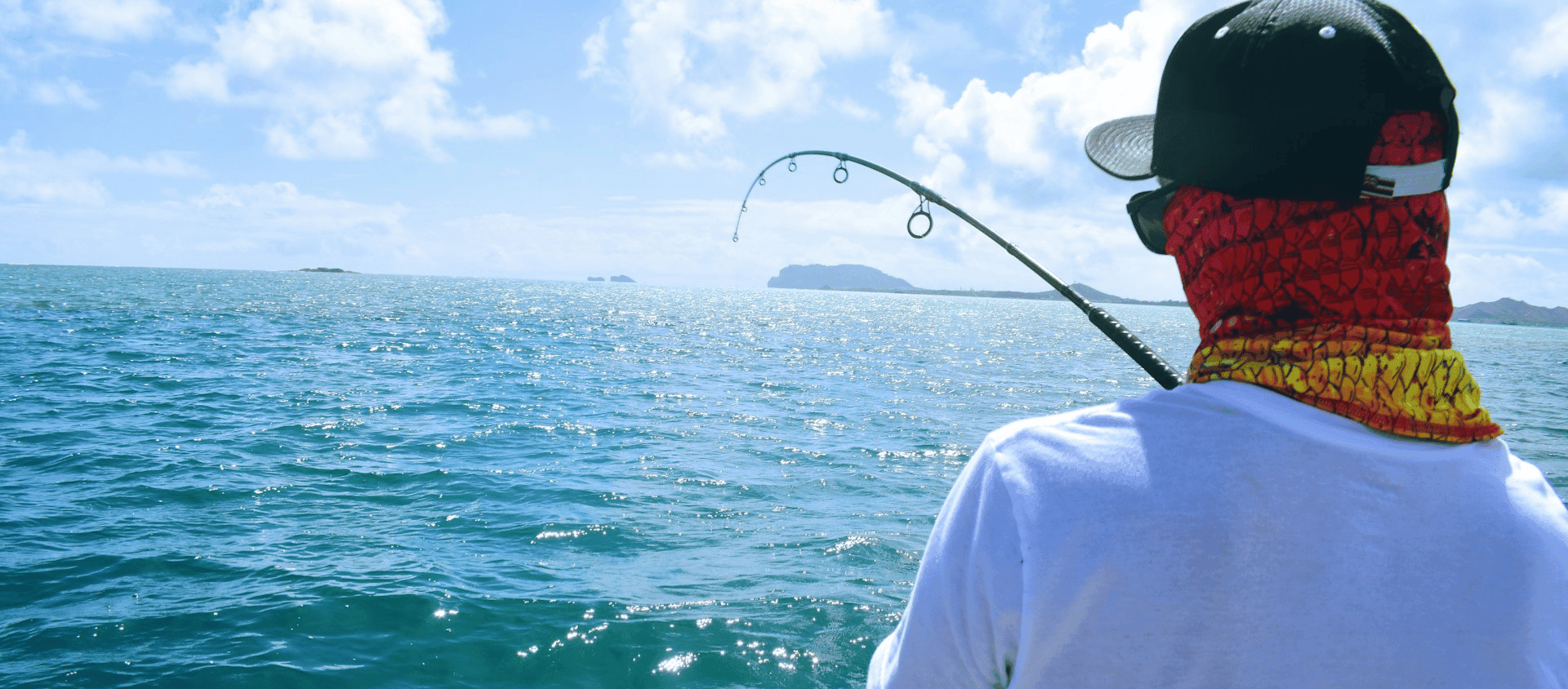 Person fishing from a boat in the open ocean in Hawaii