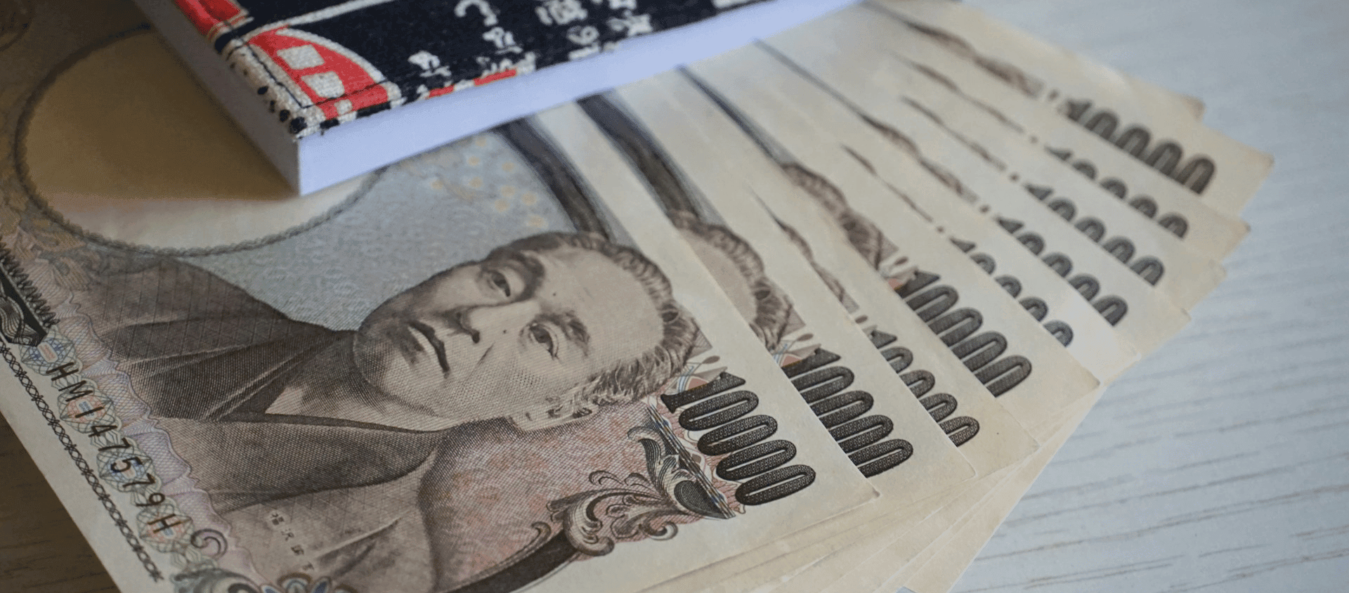 Japanese yen banknotes next to a travel guide book.