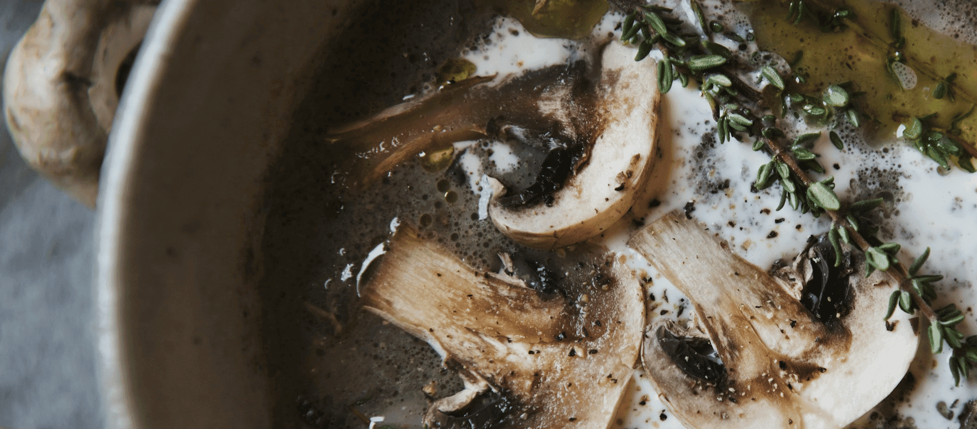 Sautéed mushrooms cooking in a pan with herbs and butter.