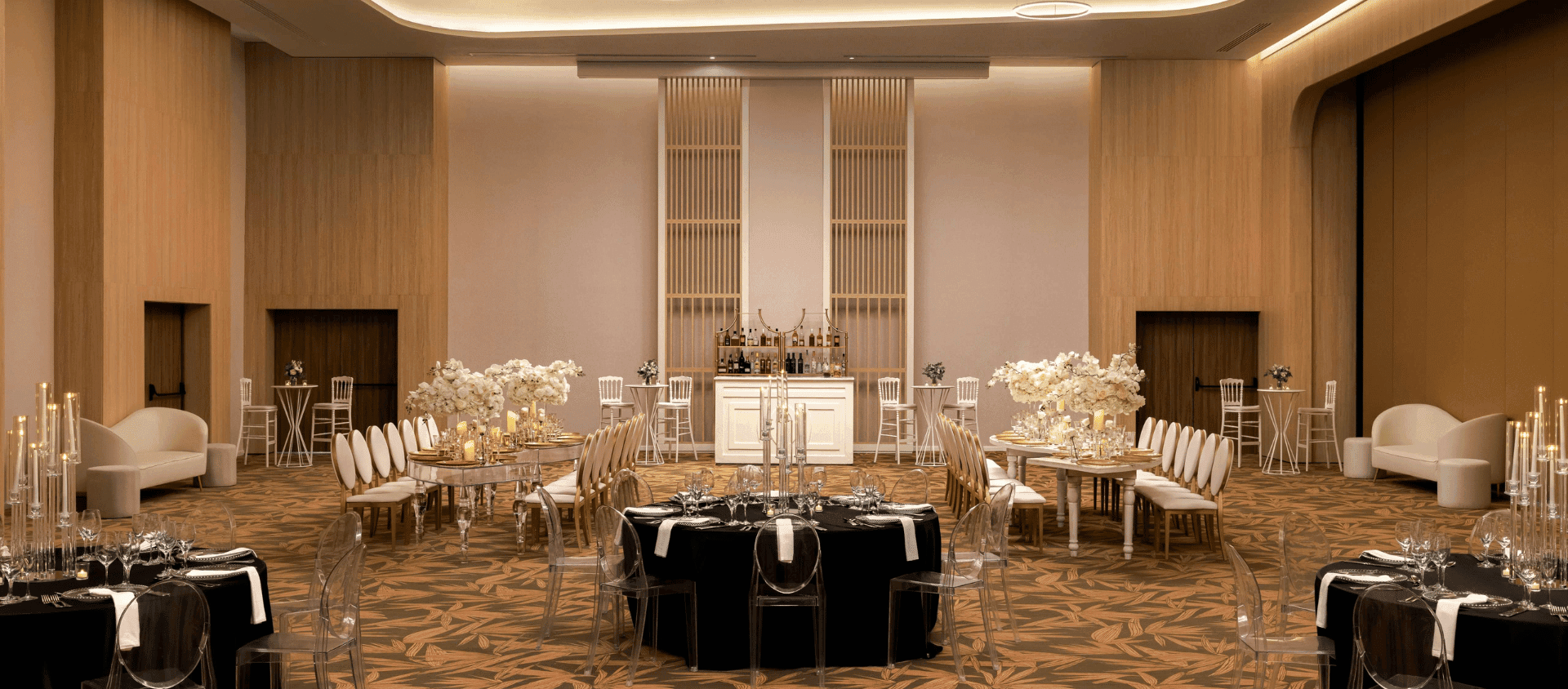 Indoor reception venue set with round tables and floral centerpieces at Dreams Playa Esmeralda.