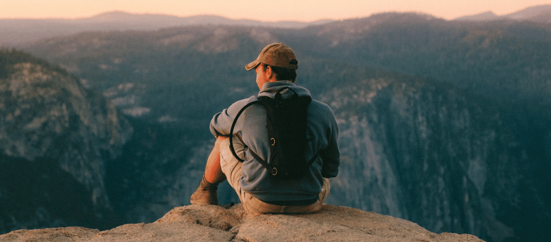 Man on rock looking over sunset in a national park.