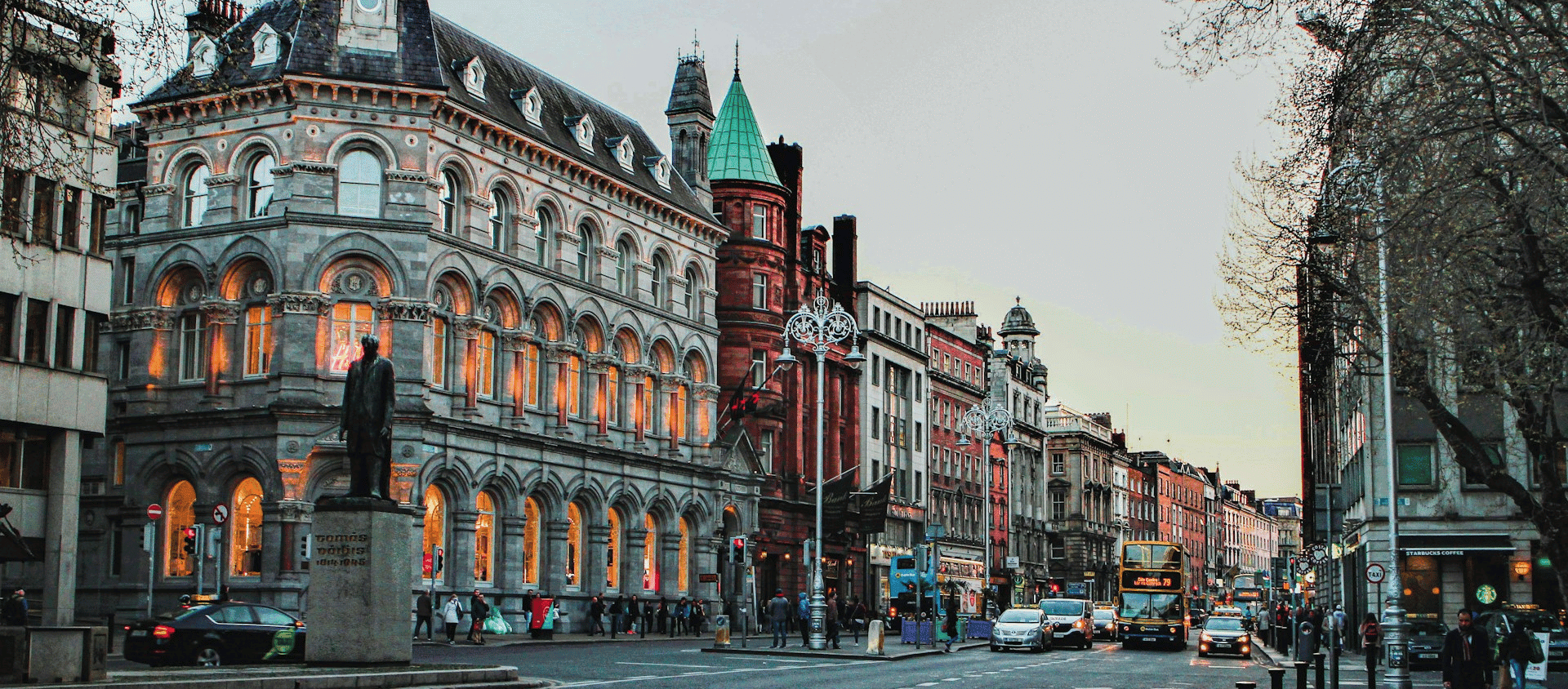 Busy city street in Dublin, Ireland lined with historic buildings and evening traffic.