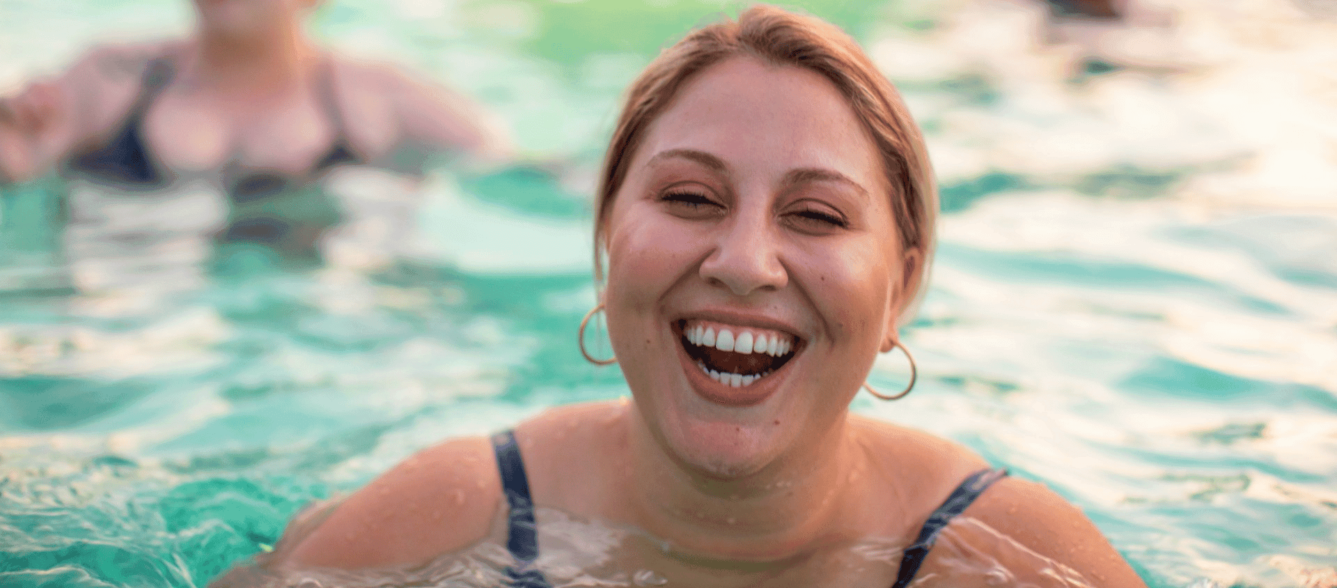 Woman smiling and laughing in a pool at a Las Vegas dayclub.
