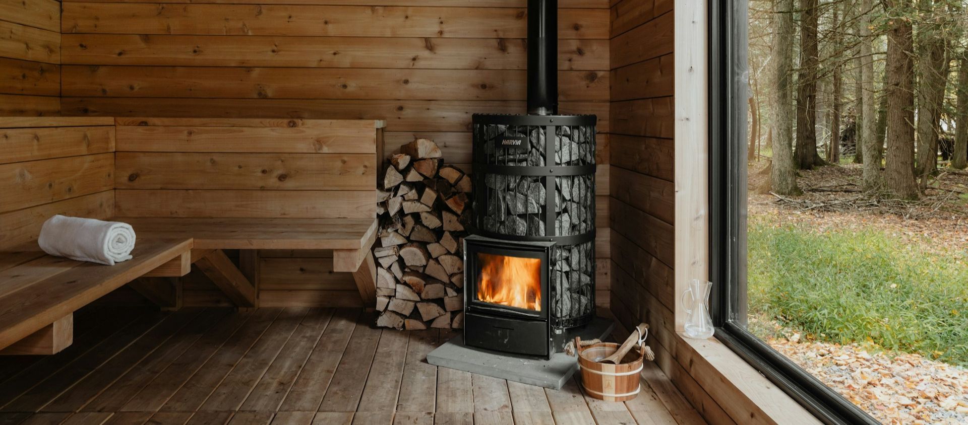 A wood-fired sauna cabin with a forest view.