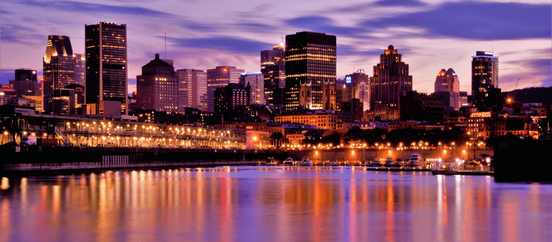 Montreal skyline at dusk reflected in calm waterfront lights