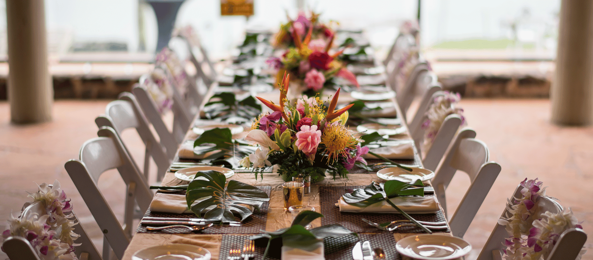 Wedding reception table at Napili Kai Beach Resort with tropical floral centerpieces.