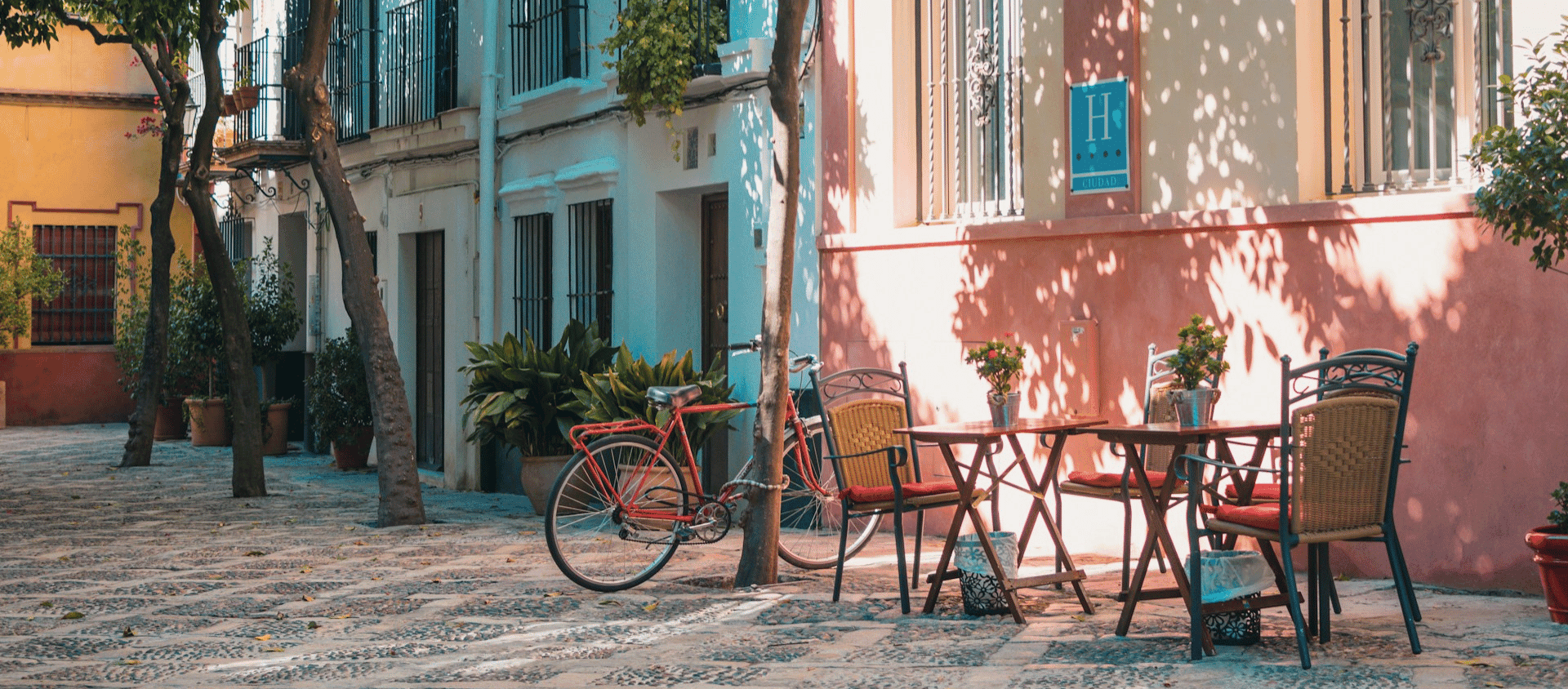 Charming Spanish street café with bicycle and pastel buildings