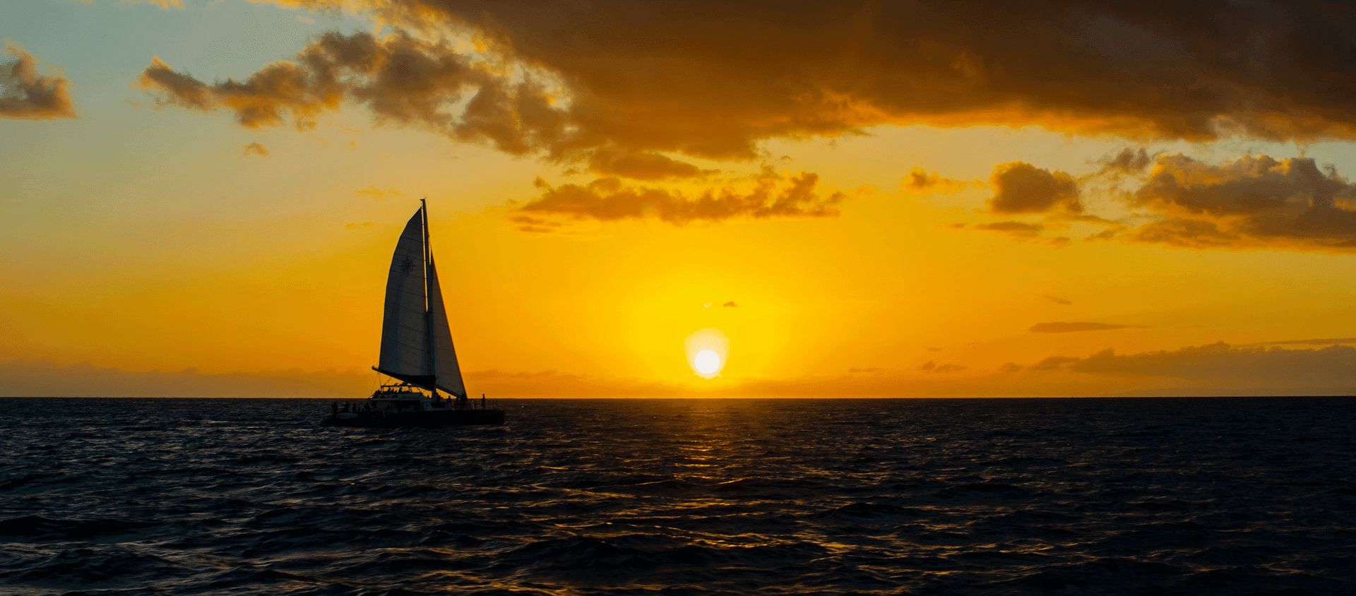 Black sailboat on a body of water.