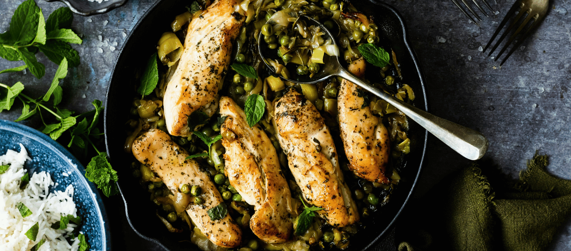 Roasted chicken with olives and herbs in a skillet.