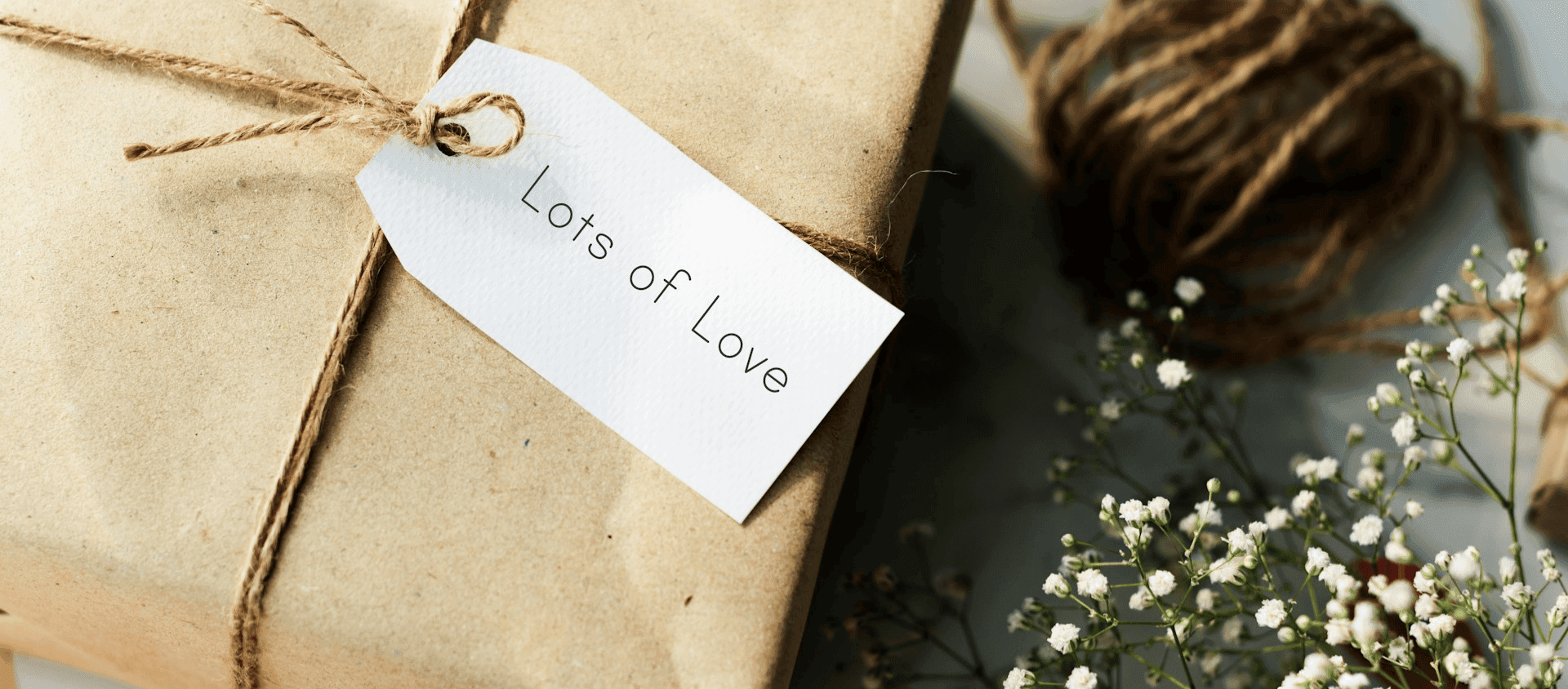 Gift wrapped in brown paper with a tag reading “Lots of Love.”