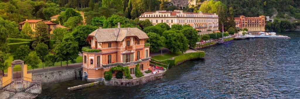 Lakeside villas surrounded by greenery along the shore of Lake Como in Italy.