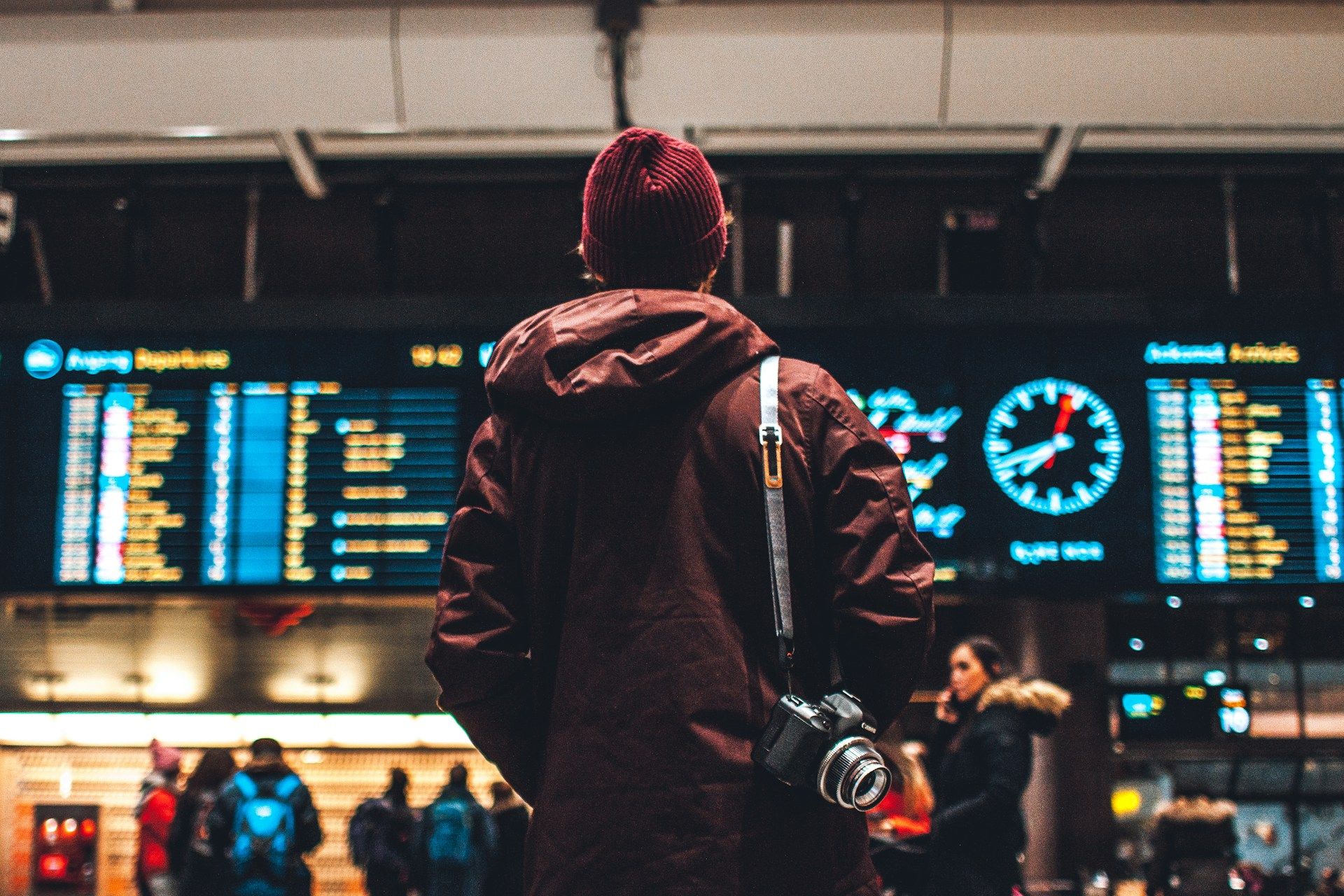 Person at an airport looking at flight departures & arrivals
