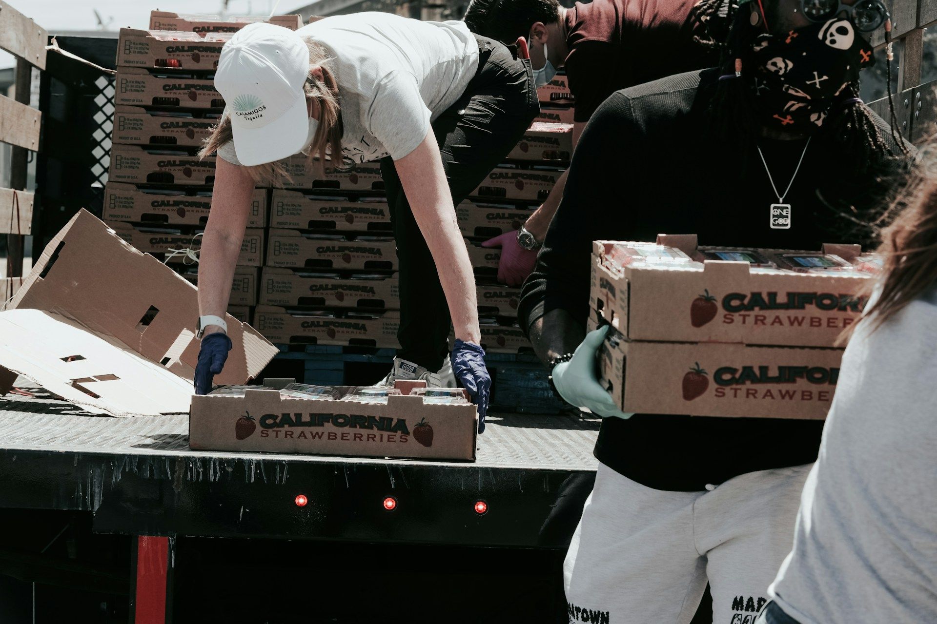 Volunteers unloading boxes of food donations from a truck.