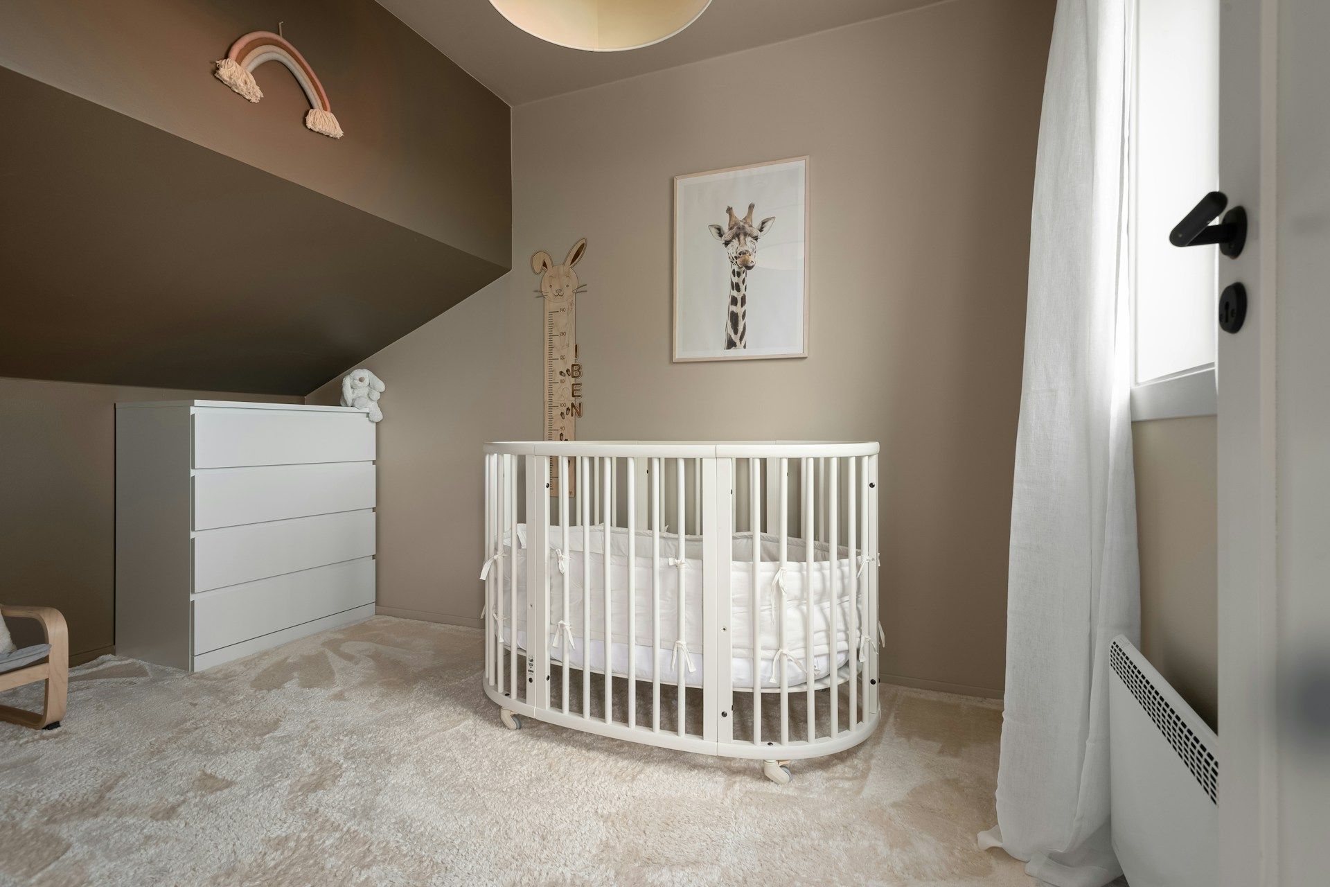 Neutral baby nursery with white crib and minimalist decor.
