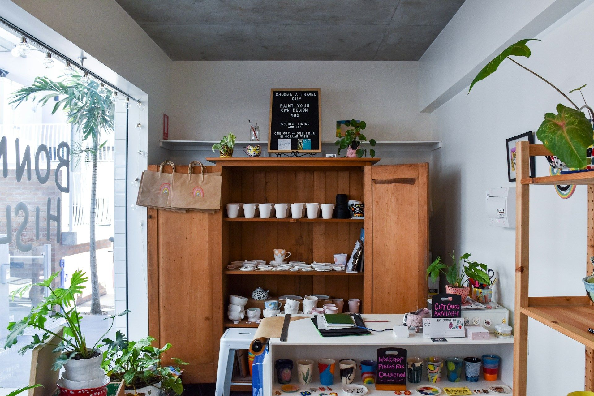 Interior of a pottery and paint-your-own ceramics studio with shelves of mugs, cups, and colorful finished pieces