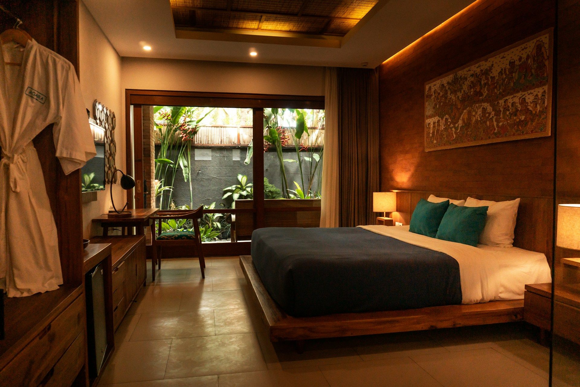 Upgraded resort room with a king bed, warm lighting, and a garden view.